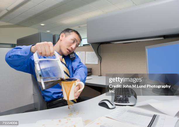 asian businessman spilling coffee on desk - careless ストックフォトと画像