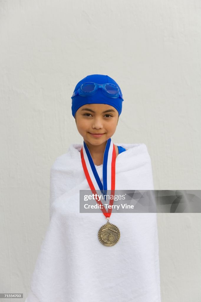 Hispanic girl wrapped in towel with swimming metal