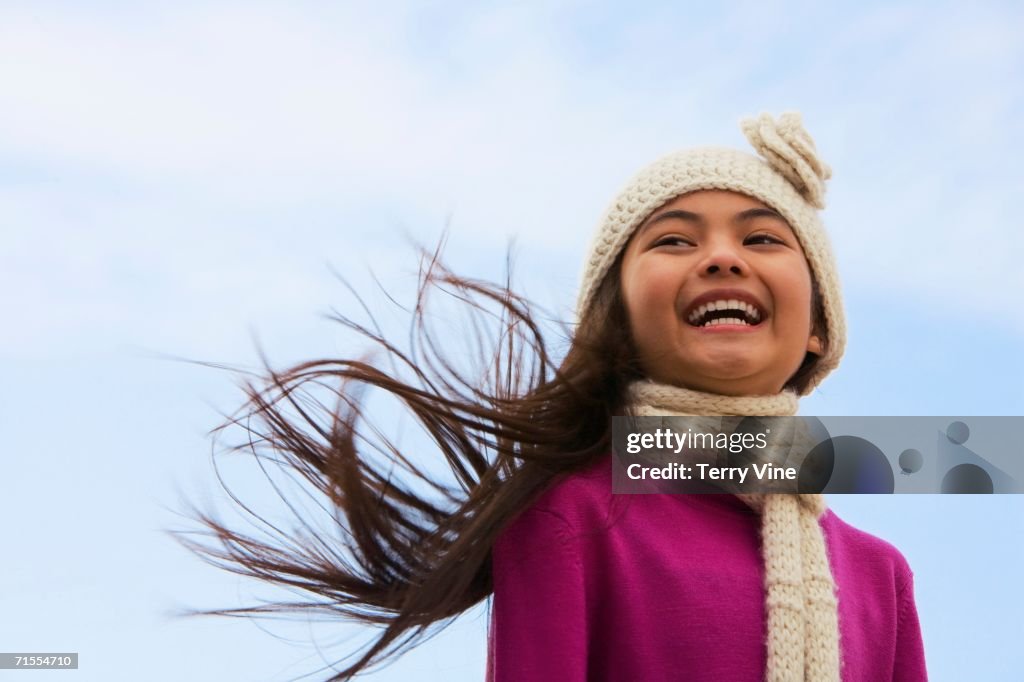 Young Hispanic girl wearing hat and scarf outdoors