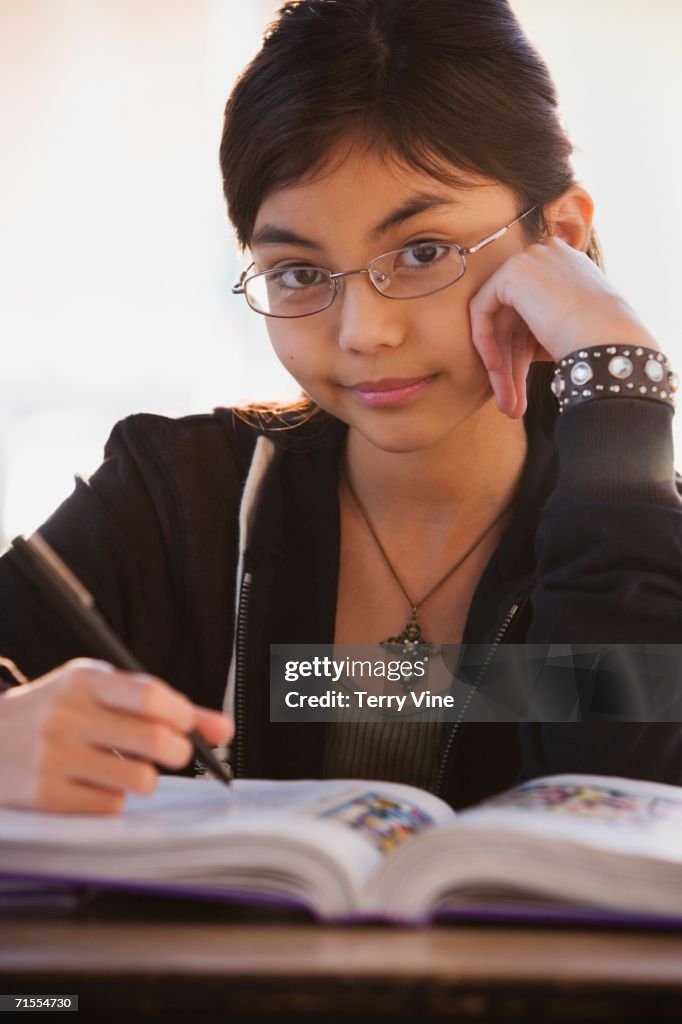 Close up of young Hispanic girl with school book