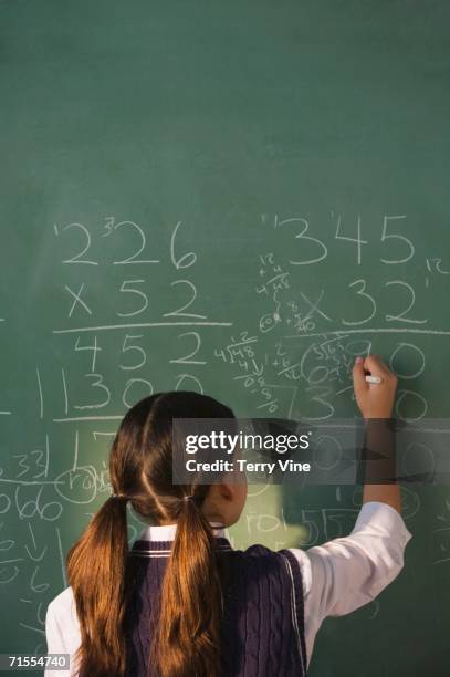 hispanic girl doing math on blackboard - chalkboard multiplication stock pictures, royalty-free photos & images