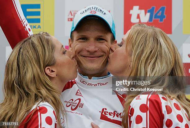 Sebastian Lang of Germany and Team Gerolsteiner is kissed by two hostesses after winning the hill valuation in the Prologue of the Deutschland Tour...