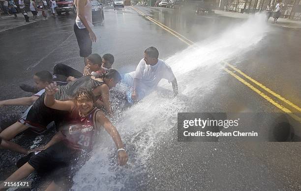 Children lying in the street cool off in the water from a fire hydrant August 1, 2006 in New York City. After declaring a heat emergency yesterday,...