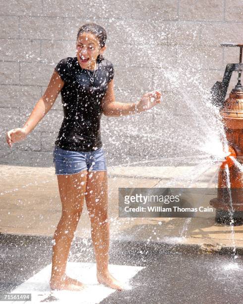 Paige Webb, 12 cools off under a fire hydrant during a heat wave gripping the northeast August 1, 2006 in Philadelphia, Pennsylvania. Record breaking...