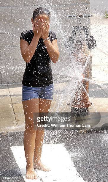 Paige Webb, 12 cools off under a fire hydrant during a heat wave gripping the northeast August 1, 2006 in Philadelphia, Pennsylvania. Record breaking...