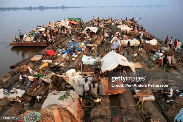 Unidentified passengers travel on a boat made of big trees on the Congo River on June 29, 2006 outside Mbandaka, Congo, DRC. The boat traveled with...