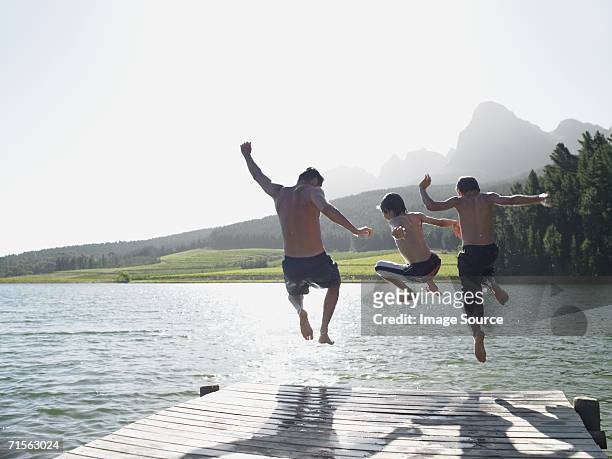 familie springen in fijord - kids at river stock-fotos und bilder