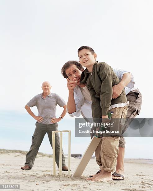 family playing cricket - beach cricket stockfoto's en -beelden