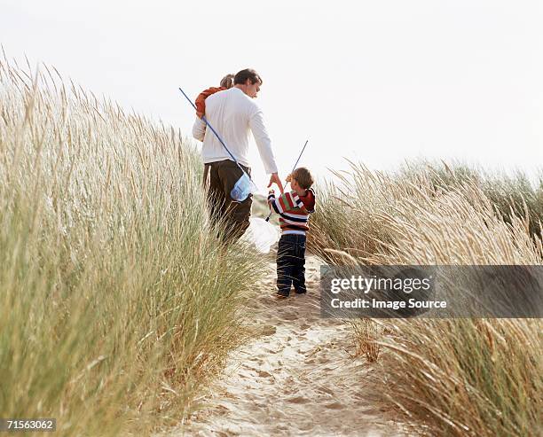 family holding fishing nets - helm riet stockfoto's en -beelden