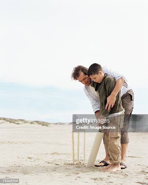 father and son playing cricket - man with cricket bat stock pictures, royalty-free photos & images