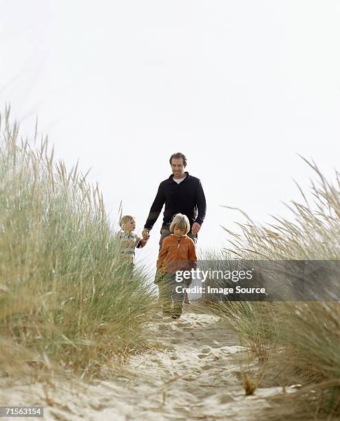 family walking down a dune - marram grass stock pictures, royalty-free photos & images