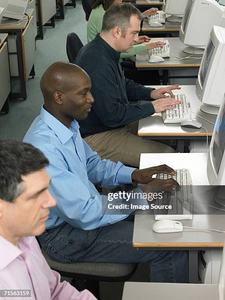 mature students using computers - avondschool stockfoto's en -beelden