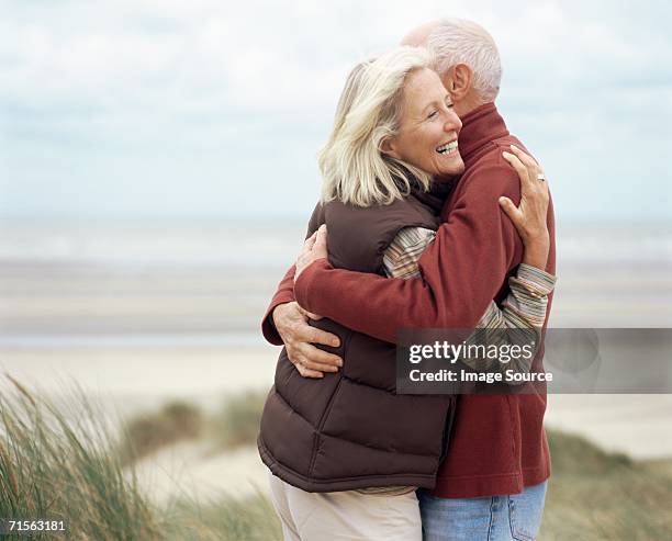 couple hugging - older couple hugging on beach stock pictures, royalty-free photos & images