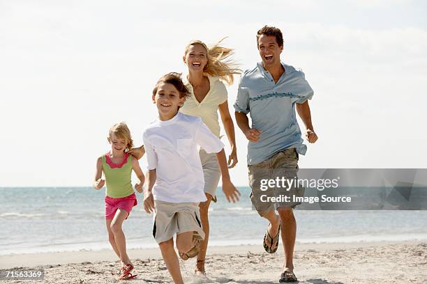 familia corriendo en la playa - family caucasian fotografías e imágenes de stock