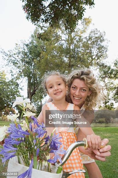 girl and mother on bicycle - amaryllis family stock pictures, royalty-free photos & images