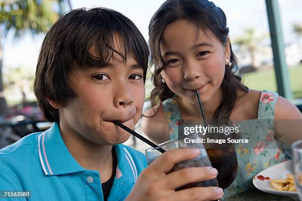 brother and sister drinking cola - asian female friends drinking soda outdoor stock pictures, royalty-free photos & images