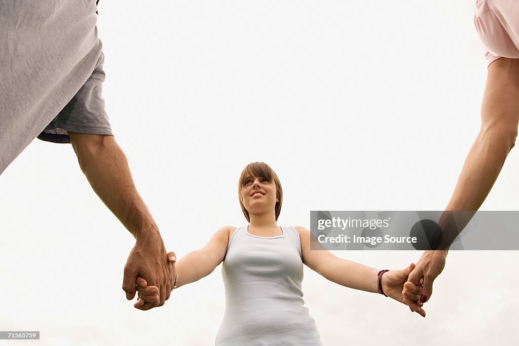 Girl holding hands with parents