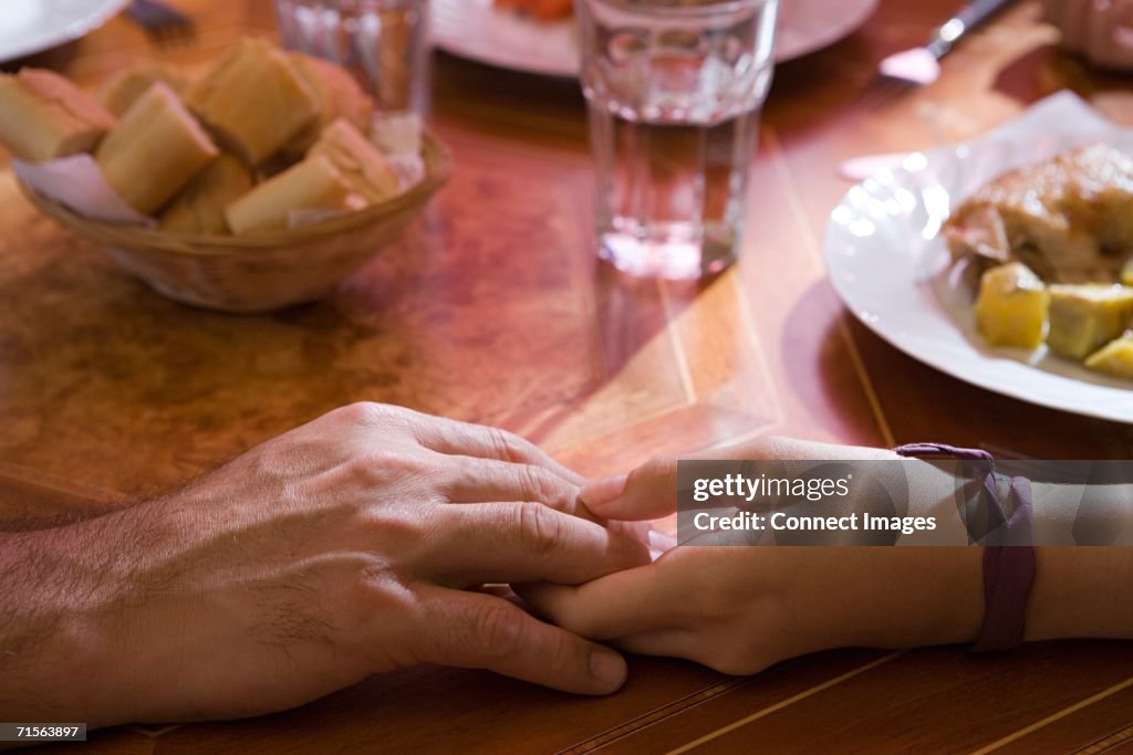 Holding hands at the dinner table