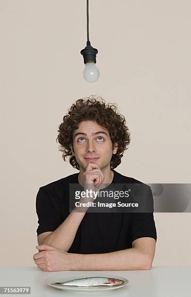 young man with a plate of raw fish - fish in bulb stock pictures, royalty-free photos & images