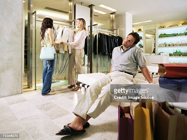 man waiting for woman in shop - ongeduldig stockfoto's en -beelden