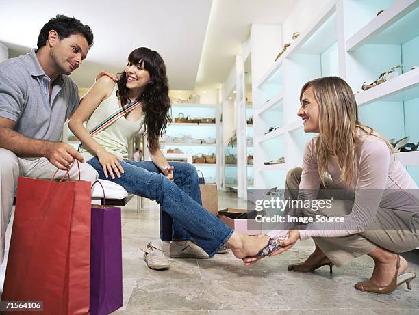 woman trying on shoes - schoenenwinkel stockfoto's en -beelden