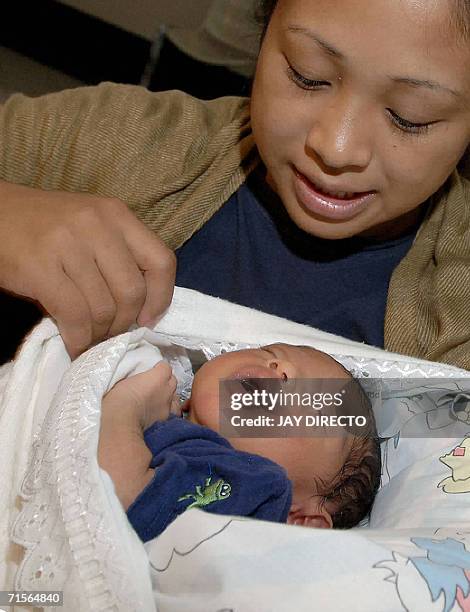 Marife Paz Jabon looks at her 11 day-old son David after they arrived at the Manila international airport, 02 August 2006 on an Orient Thai Boeing...