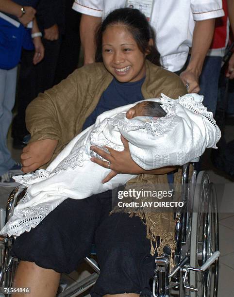 Marife Paz Jabon holds her 11 day-old son David after they arrived at the Manila international airport, 02 August 2006 on an Orient Thai Boeing 747...