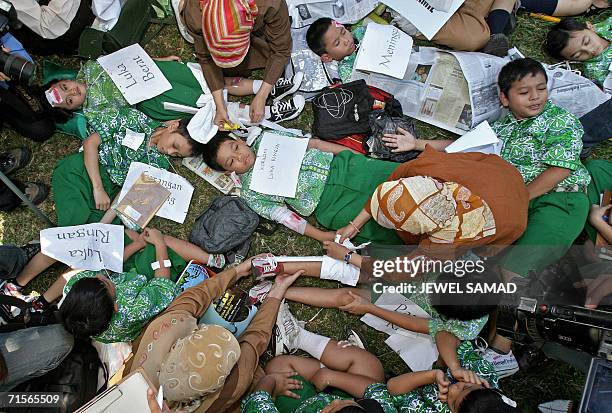 Elementary school teachers give first aid to school children during an earth quake drill in Jakarta, 02 August 2006 in which several hundreds shool...