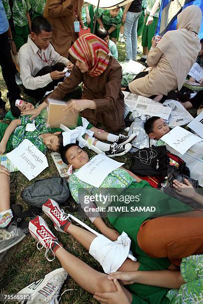 Elementary school teachers give first aid to school children during an earth quake drill in Jakarta, 02 August 2006 in which several hundreds shool...