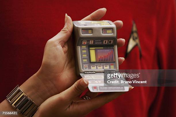 Christies employee holds up a tricorder infront of a replica Star Trek uniform on August 2, 2006 in London. Christie's New York are marking the 40th...