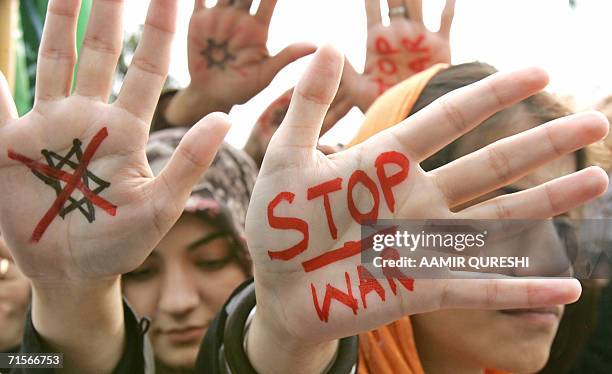 Pakistani female activists of the hardline Muttahida Majlis-e-Amal , show their hands inscribed with "Stop War" during an anti-Israel protest rally...