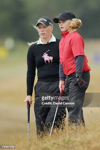 Charley Hall of England, 10 years old, prepares to chip to the 3rd green watched by her professional partner, Morgan Pressel of the USA, during the...