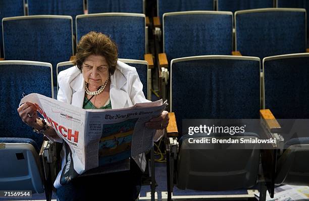 Senior White House Correspondent Helen Thomas reads the newspaper while sitting in her chair in the White House press room August 2, 2006 in...