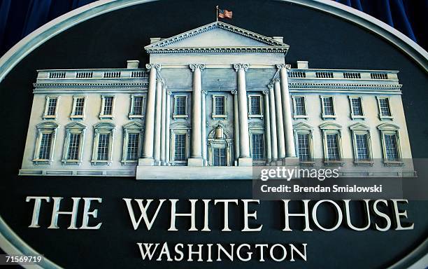 An embelem of the White House hangs behind the podium of the White House press room August 2, 2006 in Washington, DC. White House press corps will...