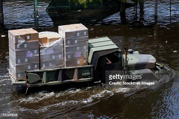 "a national guard m817 5-ton dump truck fords the floodwaters left by hurricane katrina to take supplies to the super dome in downtown new orleans, louisiana (la). " - national guard stock-fotos und bilder