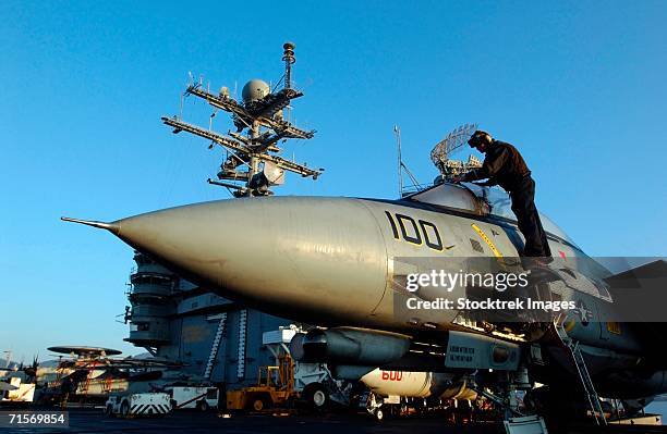 "mediterranean sea (february 21, 2006) ? a sailor assigned to the tomcatters of fighter squadron three one cleans the canopy of an f-14d tomcat on the flight deck uss theodore roosevelt" - f 14 tomcat stock pictures, royalty-free photos & images