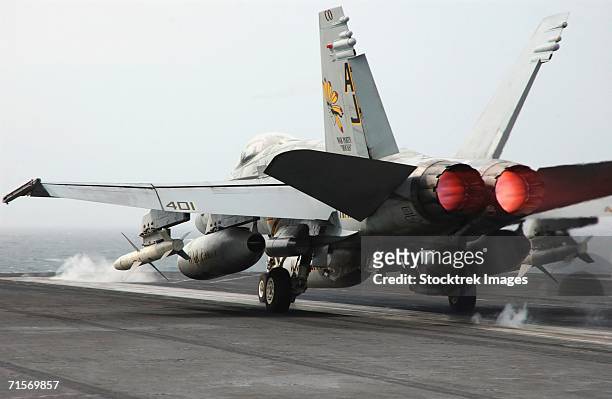 "atlantic ocean (march 10, 2006) - an f/a-18c hornet assigned to the golden warriors of strike fighter squadron eight seven (vfa-87) launches from the flight deck of uss theodore roosevelt" - fa 18 hornet photos et images de collection