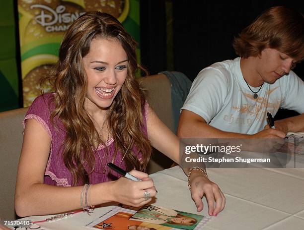 Singer/actress Miley Cyrus and actor Jason Earles of the show "Hannah Montana" sign autographs inside at the Hollywood Radio & Television Society...