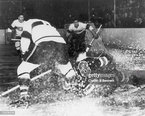 Canadian professional hockey player Tony Leswick , left wing for the New York Rangers, falls on the ice as he attempts to score a goal during a game...