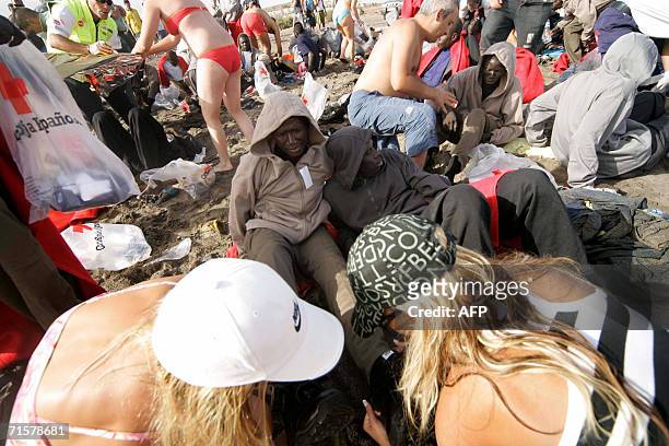 First aid workers and tourists help would-be immigrants on Tejita beach, in Granadilla on the Spanish Canary island of Tenerife, 03 August 2006. More...