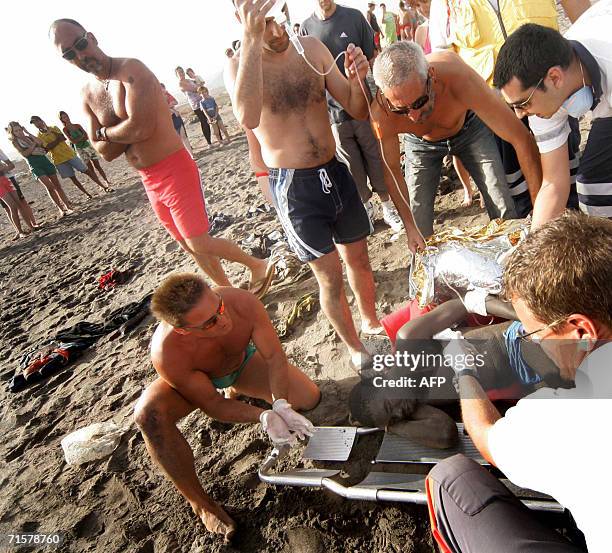 First aid workers and tourists help would-be immigrants on Tejita beach, in Granadilla on the Spanish Canary island of Tenerife, 03 August 2006. More...