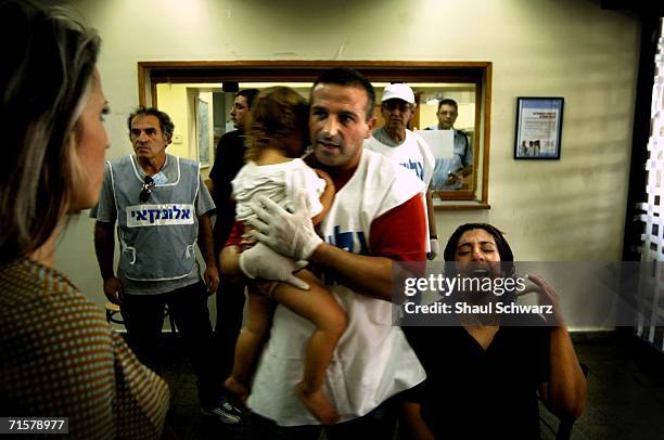 Woman and a child slightly wounded wait to be treated outside the Nahariya hospital emergency room August 3, 2006 in Nahariya, Israel. On July 28th a...