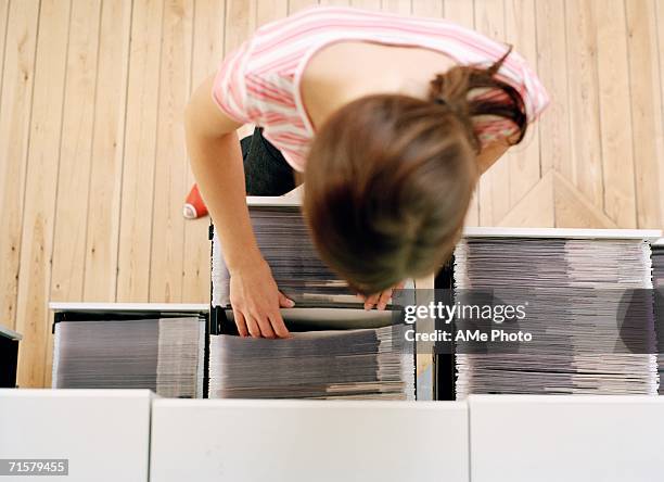 a woman searching in an archive. - archive 2006 stock pictures, royalty-free photos & images