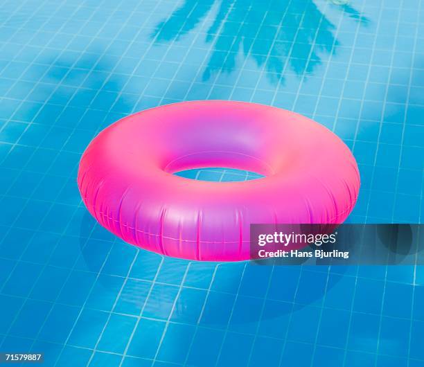 a pink inflatable ring in a pool. - salvagente foto e immagini stock