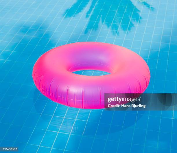 a pink inflatable ring in a pool. - 浮き具 ストックフォトと画像