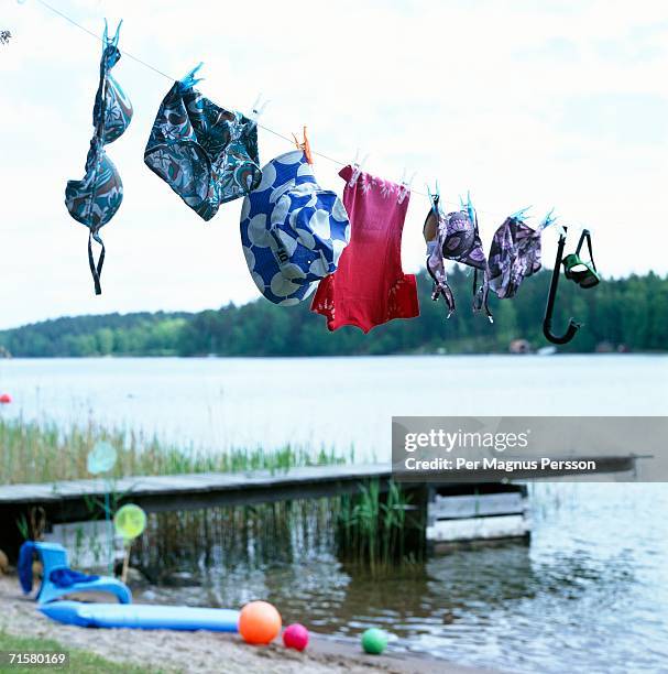 swimming costumes drying on a clothes line. - clothesline stockfoto's en -beelden