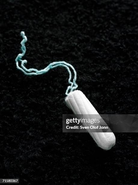 a tampon on a black background. - tampon stock pictures, royalty-free photos & images