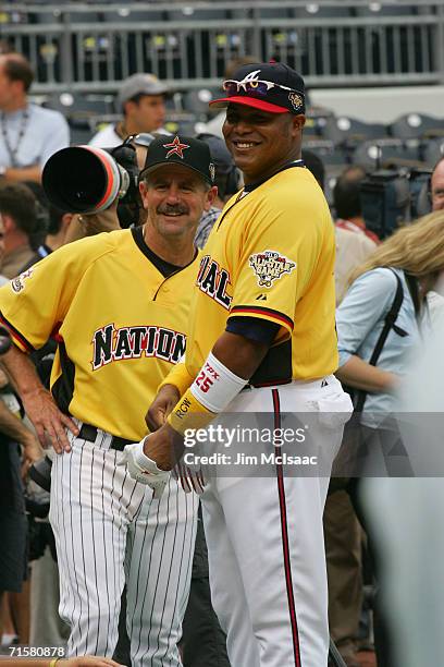 National League All-Star outfielder Andruw Jones of the Atlanta Braves smiles near All-Star manager Phil Garner of the Houston Astros during practice...