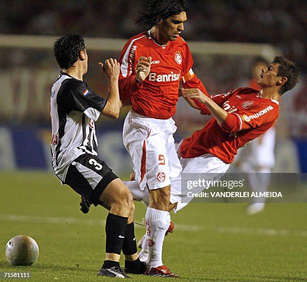 Fernandao y Alex Internacional de Brasil disputan la pelota con Edgar Balbuena de Libertad de Paraguay, en partido de semifinales de Copa...