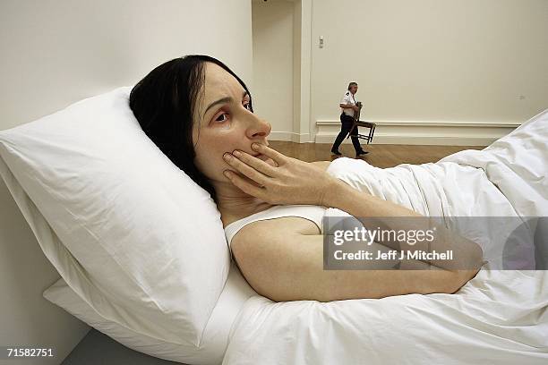 Man is see walking past to the work of Australian born, London based sculptor Ron Mueck at the National Galleries of Scotland on August 4,2006...